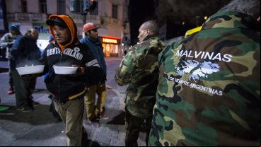 Integrantes del Centro de Ex combatientes de Malvinas ofrecen una ración de comida a los que más lo necesitan.