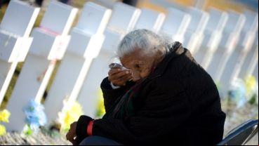 Un hombre llora en la tumba de su ser querido en el cementerio de Darwin.
