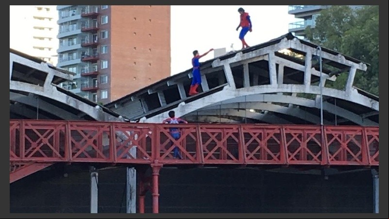 Los jóvenes vestidos como Spiderman en el techo del galpón.
