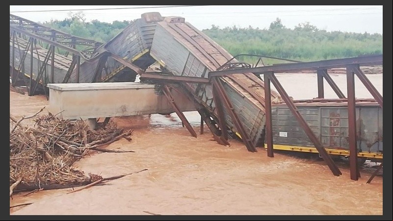 El tren sobre el puente caído y el río desbordado. 