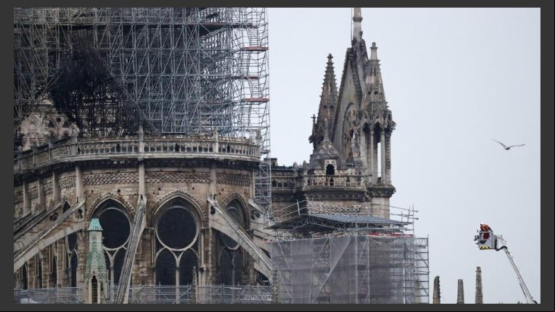 Varios bomberos trabajan en un elevador a la fachada de catedral de Notre Dame.