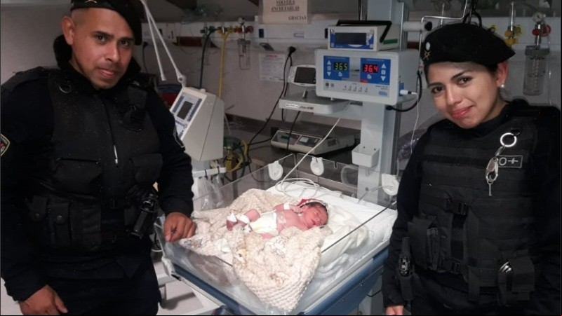 Los policías que asistieron el parto junto al bebé recién nacido.