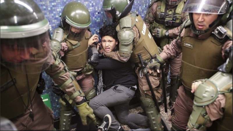 Un joven manifestante atrapado por carabineros en el metro de Santiago. 