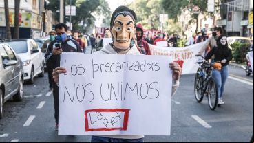 Manifestantes con su cartel de protesta.