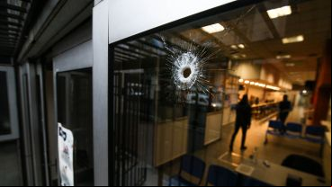 El impacto de bala en el vidrio de la puerta principal.