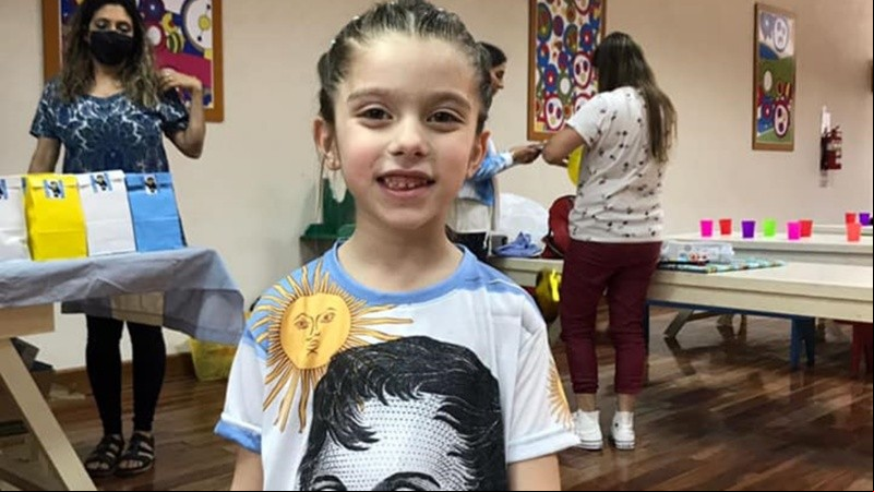 La niña con remera de Belgrano.