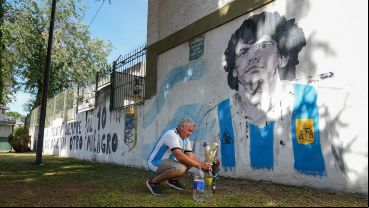 José le pone flores al mural de Maradona ubicado en Avellaneda y Santa Fe.