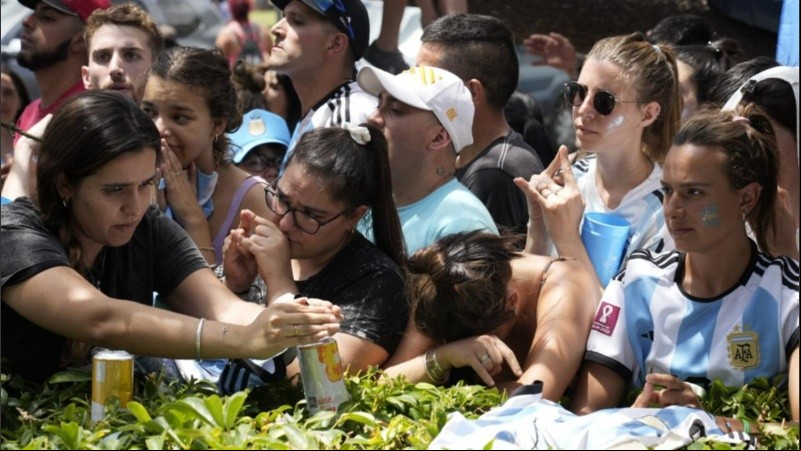 Hinchas de la selección argentina y el clásico gesto de elevar dos dedos para cortar la suerte del rival.