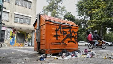 Un container de residuos de separación en Viamonte y Moreno, casi rebalsado y con basura alrededor.
