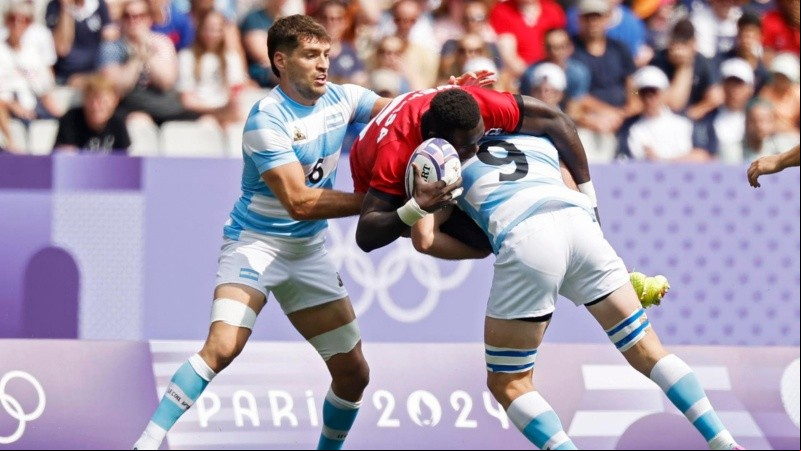 Kevin Wekesa de Kenia en acción contra Santiago Alvarez y Matias Osadczuk de Argentina