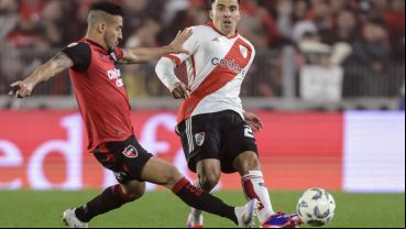 Cardozo y Acuña, que debutó en River, disputan una pelota en el Monumental.