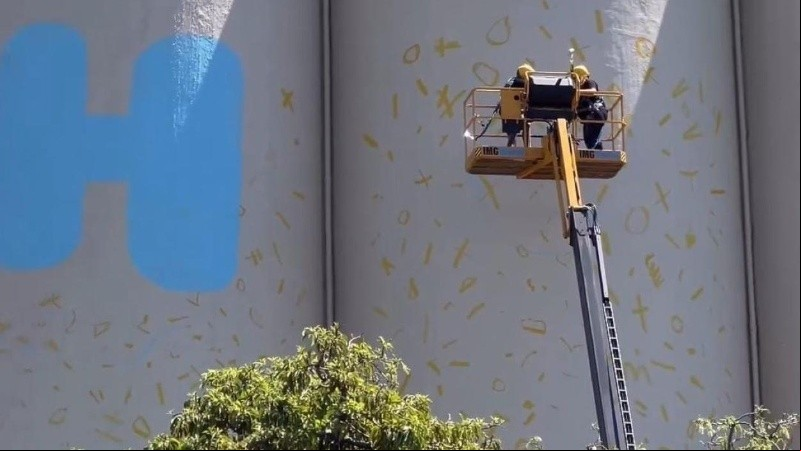 El famoso muralista argentino ya comenzaba a pintar su conocida frase en la fachada que mira al centro.