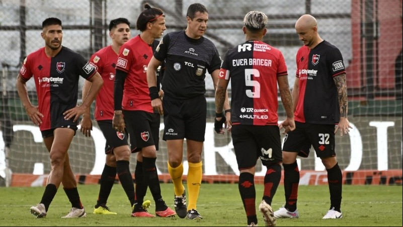 Los futbolistas rojinegros rodean al árbitro Echavarría en Sarandí.