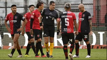 Los futbolistas rojinegros rodean al árbitro Echavarría en Sarandí.