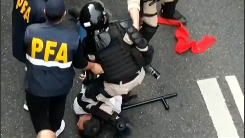 Captura 2: un agente retiene por la fuerza contra el piso al cura.